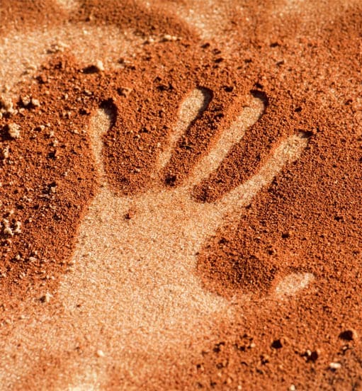 Empreinte de main dans la terre rouge